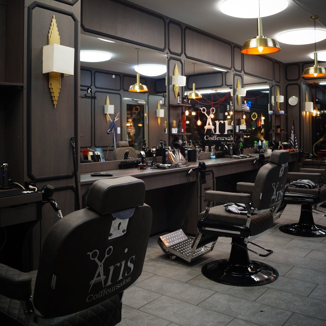 Styling-Stationen mit Ledersesseln und Messing-Pendelleuchten